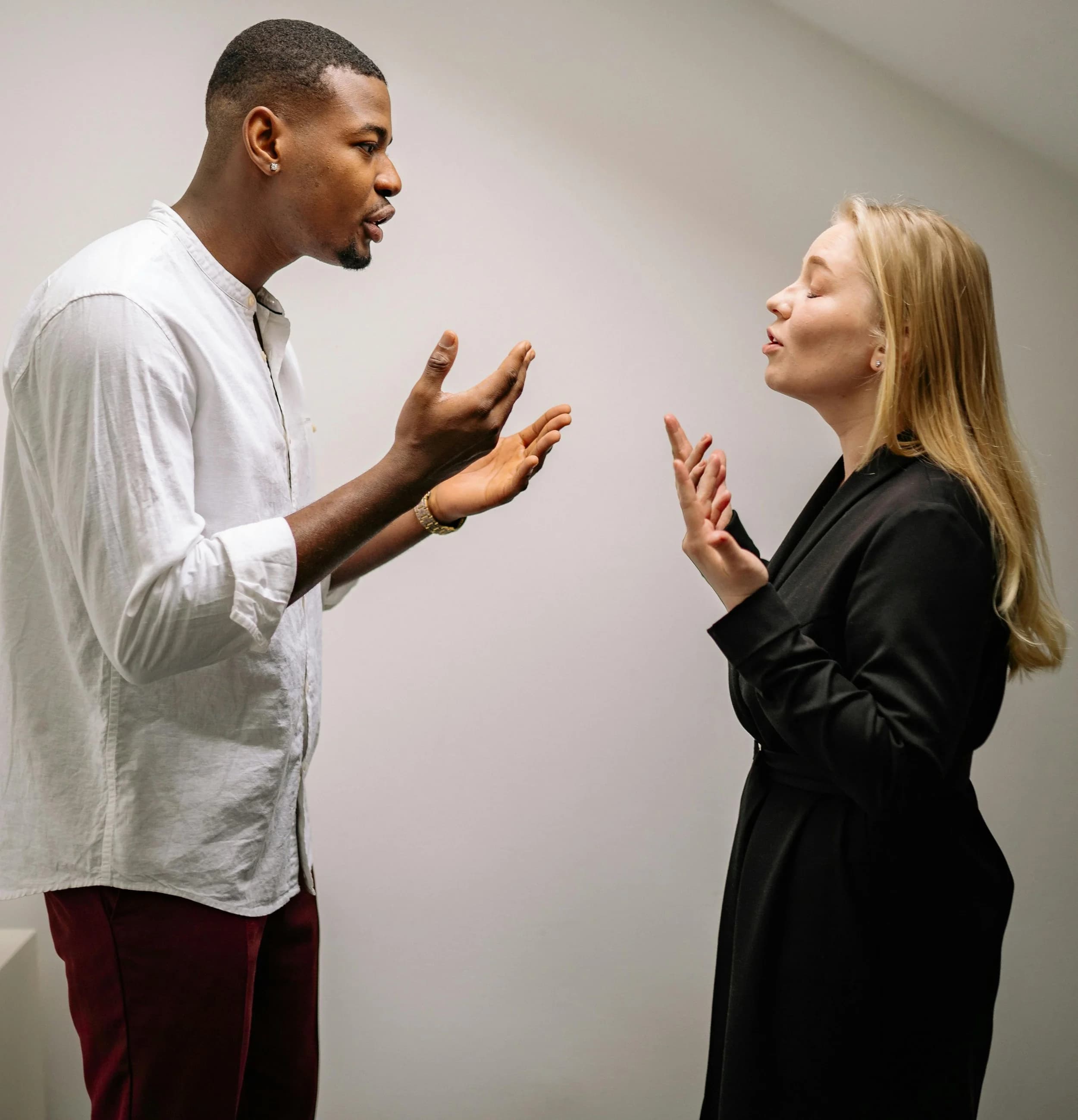 Two people standing face to face in a tense conversation, both gesturing